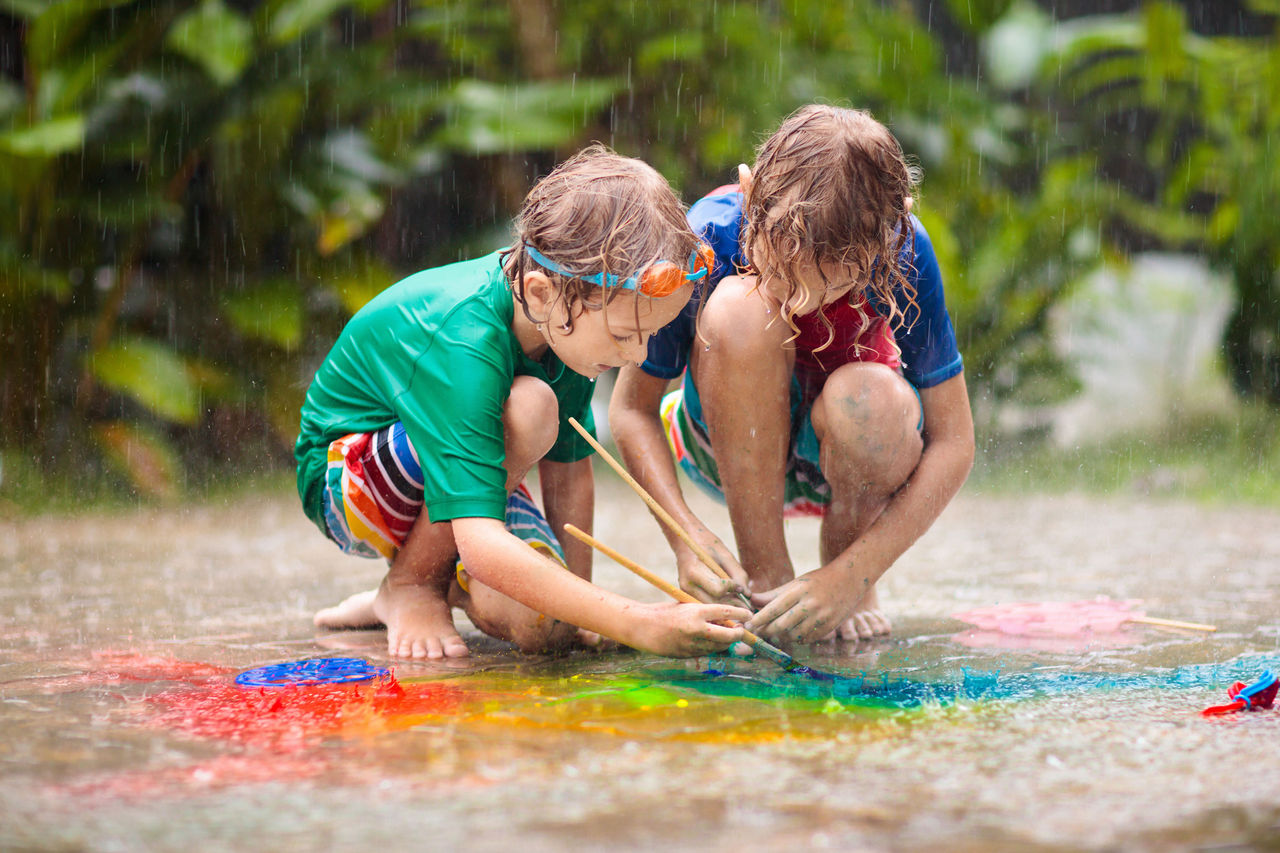 Two children enjoying summer activities in a sprinkler