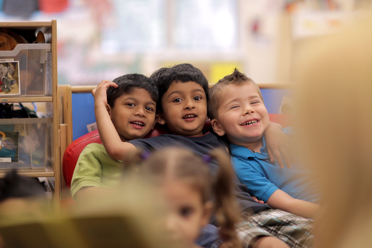 Three small children sitting in a row